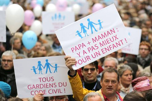 Protestors hold placards and balloons during a demonstration against a draft law to allow same-sex marriage in Paris