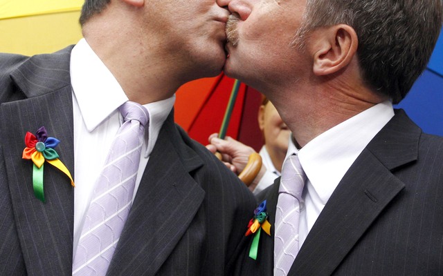 Homosexuals Brazilian Toni Reis and British David Harrad of Macclesfield city kiss for a picture after their wedding in Curitiba